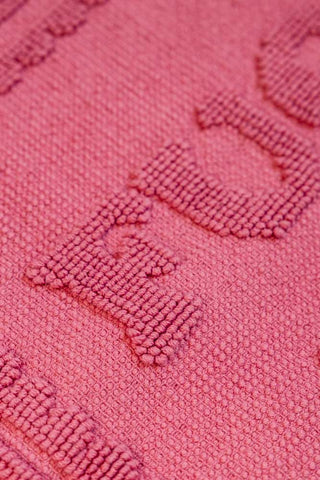 Detail showing the raised slogan letter detail on the Fucking Filthy Hot Pink Bath Mat.