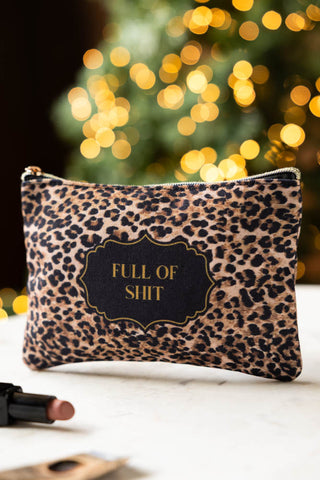 Full of Shit Leopard Print Canvas Pouch shown on a marble surface with a lipstick. 