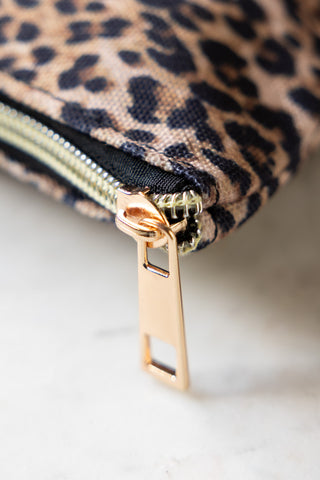 The gold zip of the Full of Shit Leopard Print Canvas Pouch. 