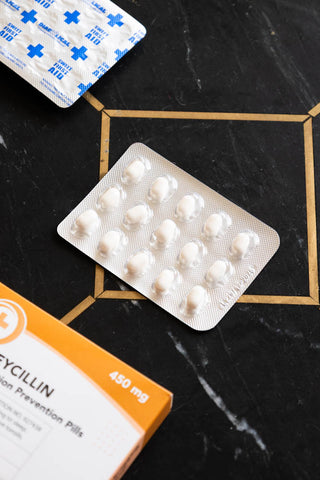 The mints from inside the Snoreycillin Mints Pill Packet, displayed on a dakr surface.