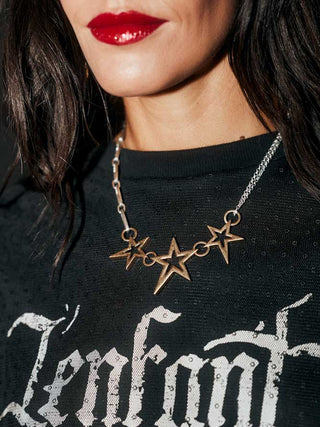 Close-up of the Gold 3 Star Necklace being worn by a model.