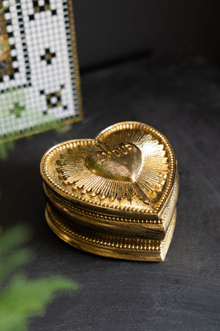 The Gold Amour Heart Trinket Box shown against a black surface. 