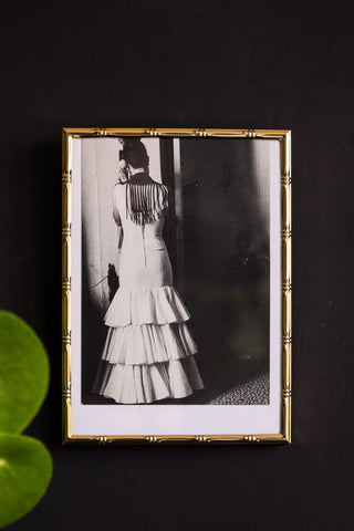 Lifestyle image of the Gold Bamboo Effect Photo Frame hung on a wall