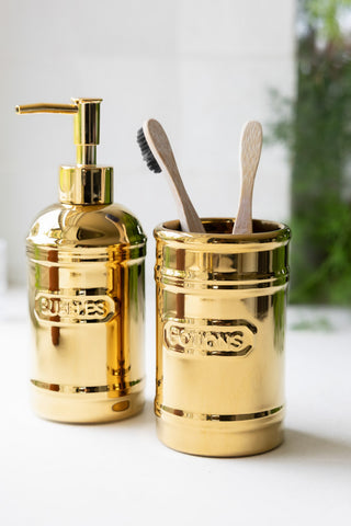 The Gold Bubbles & Potions 2-Piece Bathroom Set shown with bamboo toothbrushes. 