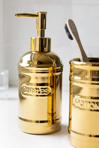 The soap dispenser of the Gold Bubbles & Potions 2-Piece Bathroom Set. 