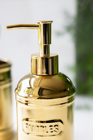 Close up of the soap dispenser in the Gold Bubbles & Potions 2-Piece Bathroom Set. 