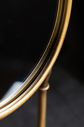 The curved underside of the Gold Bird Legs Tabletop Mirror. 