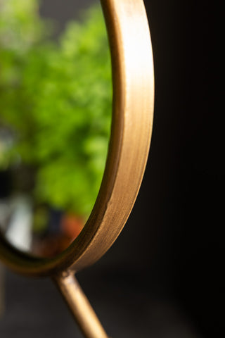 The edge of the Gold Bird Legs Tabletop Mirror, showing the distressed gold finish. 