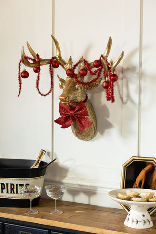 The Gold Christmas Reindeer Wall Art Decoration styled on a wall above a sideboard with various bar/party accessories on.