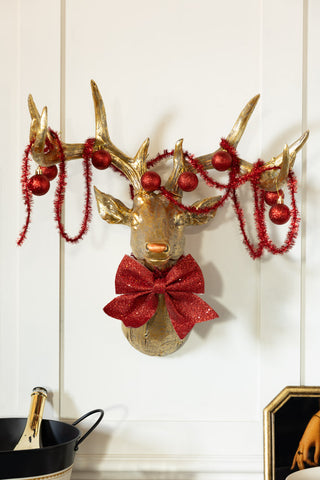 The Gold Christmas Reindeer Wall Art Decoration styled on a white wall.