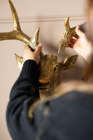 Someone placing the antler on the Gold Christmas Reindeer Wall Art Decoration.