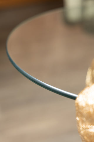 Close-up of the edge of the tabletop of the Gold Elephant Side Table With Glass Top.