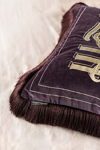 Black blanket with gold text on a white surface