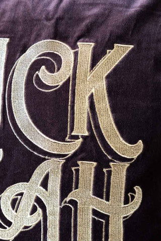 Close-up image of the Gold Embroidered Fuck Yeah Cushion