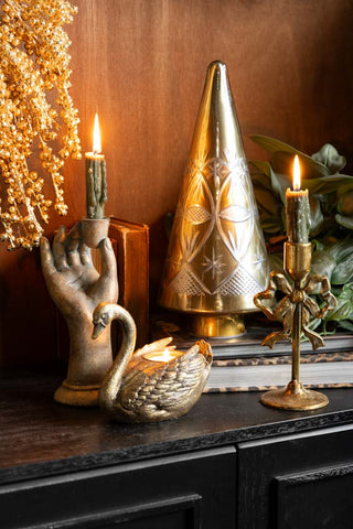 The Gold Etched Christmas Tree Display Ornament styled on a dark sideboard with some lit candles, books and greenery.