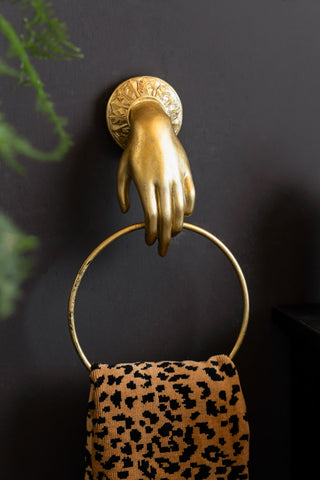 Gold Hand Towel Rail shown on a black wall with a leopard towel hanging from the ring. 