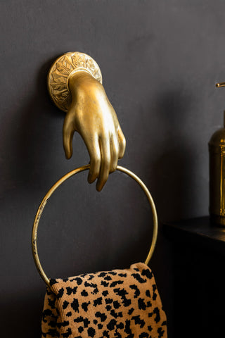 The Gold Hand Towel Rail shown against a black wall. 