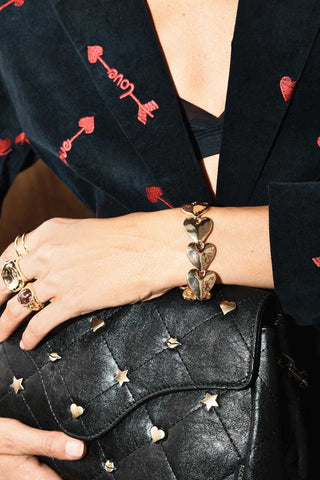 Close-up of the Gold Heart Bracelet worn by a model.
