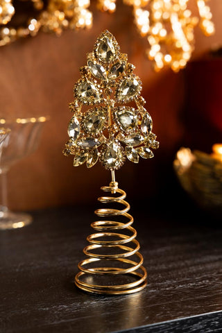 The Gold Jewelled Christmas Tree Topperon a dark wooden surface.