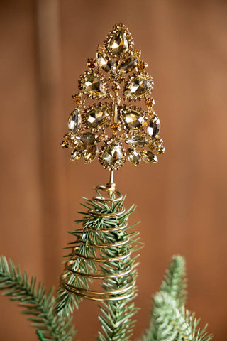The Gold Jewelled Christmas Tree Topper on the top of a tree.