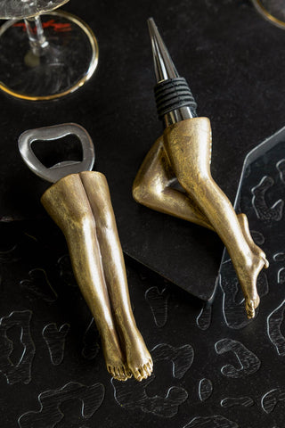 The Gold Legs Bottle Opener & Stopper Set shown on a black leopard surface. 