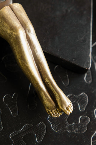 The gold legs of the Gold Legs Bottle Opener & Stopper Set. 