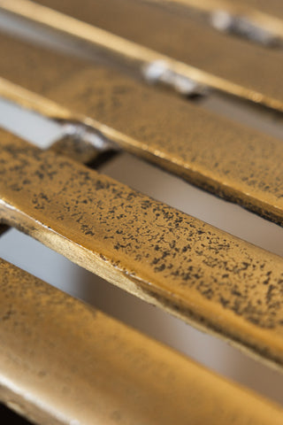 The distressed texture of the gold metal surface of the Gold Metal Bench. 