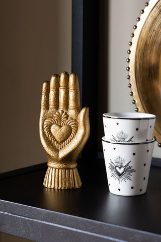 Image of the Gold Milagro Heart Hand Decorative Ornament on a cabinet