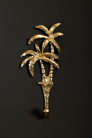 The Gold Palm Trees Wall Hook on a black wall.