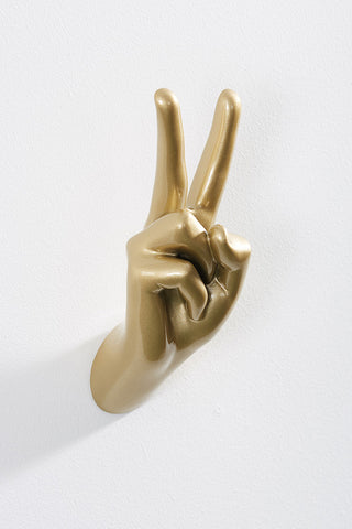 The Gold Peace Hand Wall Art & Coat Hook displayed on a white wall.