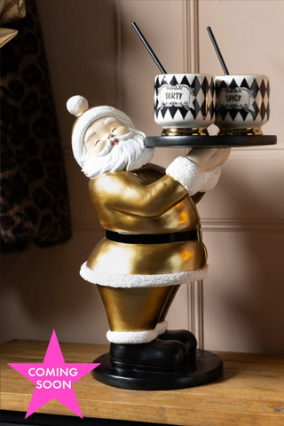 The Gold Santa Butler Christmas Decoration styled with two cocktail cups on. Shown with a pink star icon that reads 'coming soon'.