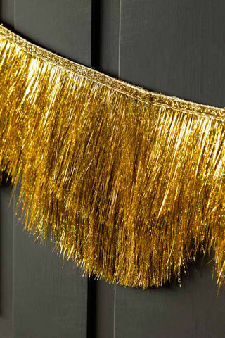 Close-up of the Gold Scalloped Tinsel Garland styled on a black background.