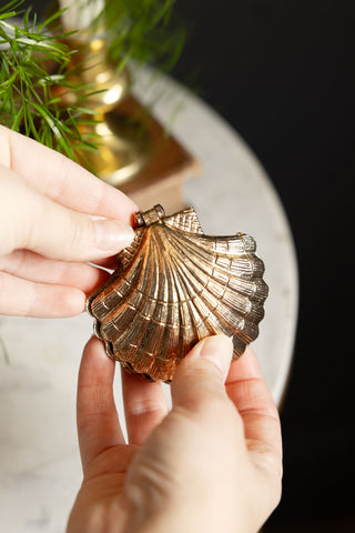 The Gold Shell Trinket Dish being held in someone's hands.