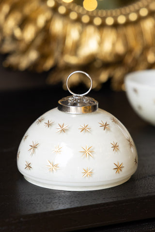 The lid of the Gold Star Christmas Candle Bauble Ornament, displayed on a dark wooden surface.