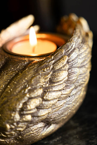 The Gold Swan Tealight Holder shown with the candle lit. 