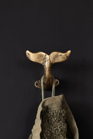 Lifestyle image of the Gold Whale Tail Coat Hook