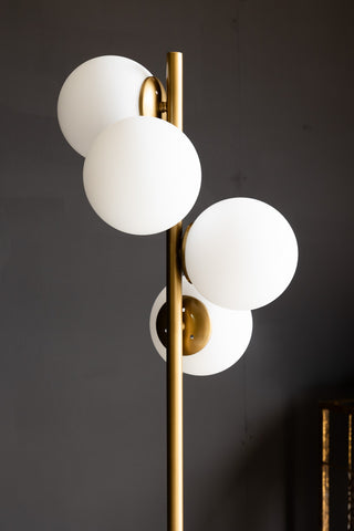Lifestyle image of the Gold & White Opaque Globe Floor Lamp.