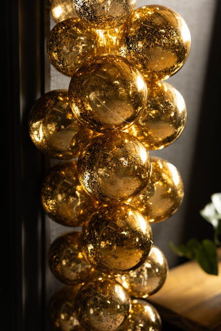 Close-up of shot of the Gold Antique-Effect Bauble Christmas Garland hanging vertically.