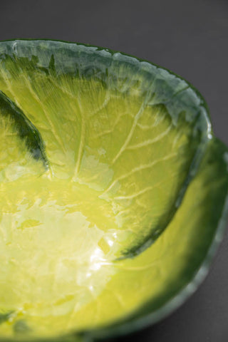 Detail image of the green cabbage bowl on a dark table