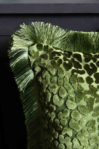 Close-up of the corner of the Green Leopard Velvet Cushion with Fringe Trim.