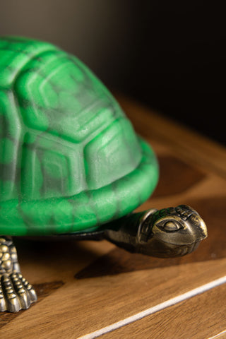 A close up of the gold head of the Green Speckled Glass Turtle Table Lamp. 