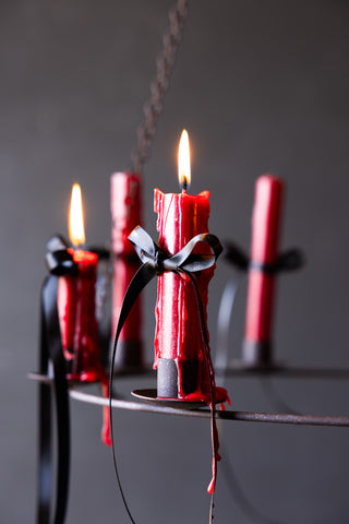 Detail shot of the Chic Metal Candlestick Chandelier with Halloween styling on a black background.