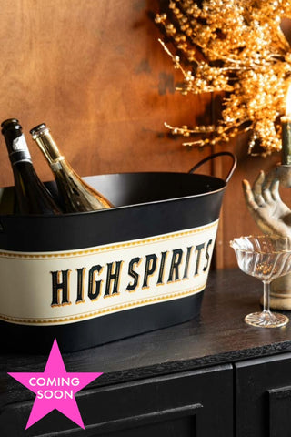 The High Spirits Wine Cooler styled on a sideboard with some accessories, with a 'coming soon' icon in the bottle left hand corner.