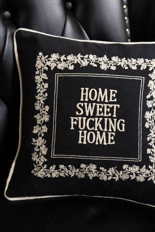 The Home Sweet Fucking Home Embroidered Cushion on a black chair.