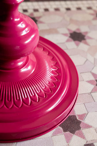 The base of the Hot Pink Heart Metal Side Table shown against a pink tiled runner. 