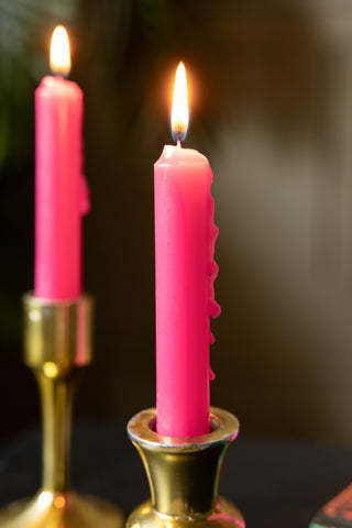Image of the Hot Pink Short Dinner Candle in a gold candlestick with the candle lit.