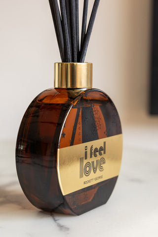 The I Feel Love Cedarwood & Frankincense Reed Diffuser seen from the side, displayed on a white surface.