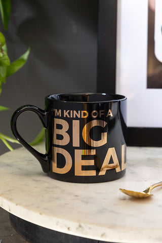 The I'm Kind Of A Big Deal Mug displayed on a marble surface with a spoon and art print.