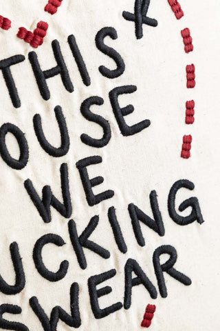 Close-up of the embroidery on the In This House We Swear Embroidered Cushion.