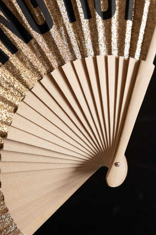 The wood frame of the It's Fucking Hot Gold Glitter Fan. 